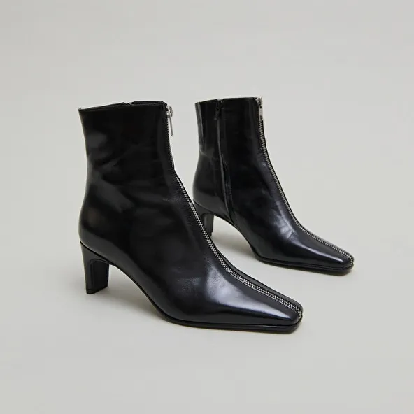 Heeled ankle boots with front zippers in black leather