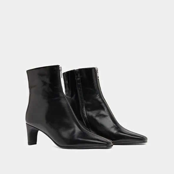 Heeled ankle boots with front zippers in black leather