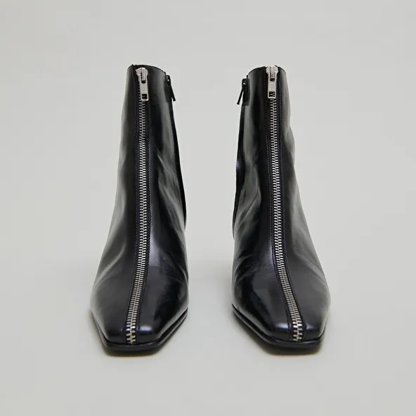 Heeled ankle boots with front zippers in black leather